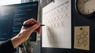 Um calendário de parede com vários dias marcados, simbolizando a passagem do tempo e o planejamento para aprender a programar em Python, com ícones de relógio e código sobrepostos.